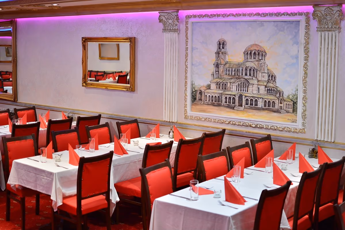 Unikat 2 dining room with red chairs and a painting of the Alexander Nevsky Cathedral