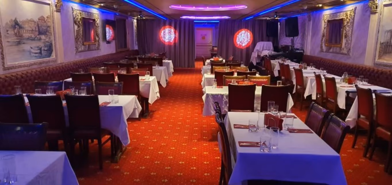 Unikat 2’s dining hall with red carpet and white tablecloths